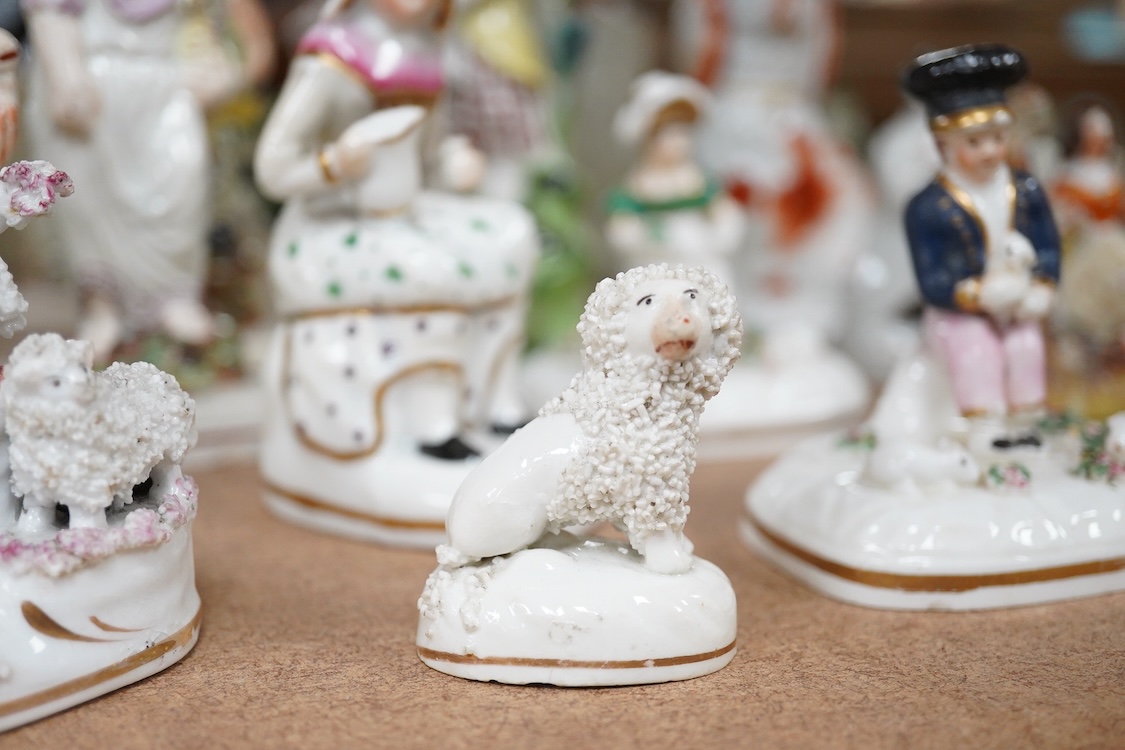 A collection of 19th century and later Staffordshire figures, mostly figural examples, including a pair a rare pair of porcelain seated figures with rabbits and a candle extinguisher, largest 15cm high (15)